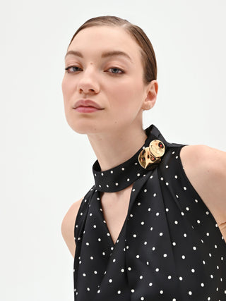 Abito nero a pois con collo drappeggiato