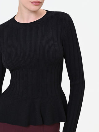Maglia nera a costine con fondo a peplo