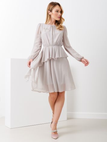 Abito corto con balze Questo abito corto a balze ha la manicha lunga trasparente e lo scollo rotondo. Elastico in vita crea un effetto a sbuffo della blusa. Le balze asimmetriche donano movimento all'abito. Retro con scollo a goccia e chiusura con bottoncino madreperla. Completa l'abito una spilla removibile che dona luce e ricchezza a un abito dal gusto intramontabile. Il capo è interamente Made in Italy. .La modella è alta 1,73 ed indossa la taglia S. Rinascimento