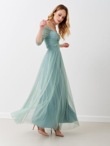 Abito lungo con manica arricciata Questo abito romantico in tulle color verde menta ti farà sentire una principessa. Le maniche in tulle presentano un'arricciatura e il corpetto ha un nodo sul davanti. Zip posteriore invisibile. La gonna fluida lo rede perfetto per i tuoi momenti più eleganti. Il capo è interamente Made in Italy. La modella è alta 1,73 ed indossa la taglia S. Rinascimento