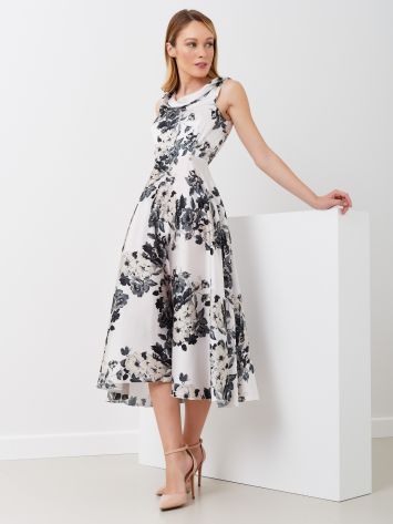 Abito midi stampa fiori a contrasto Abito midi con stampa floreale a contrasto bianco con piccoli fiori neri. Scollo a gronda. Chiusura posteriore con zip invisibile. Gonna fluida. Tutto l'abito è in raso satin. Indossalo con un tacco per le occasioni speciali.La modella è alta 1,73 ed indossa la taglia S. Rinascimento