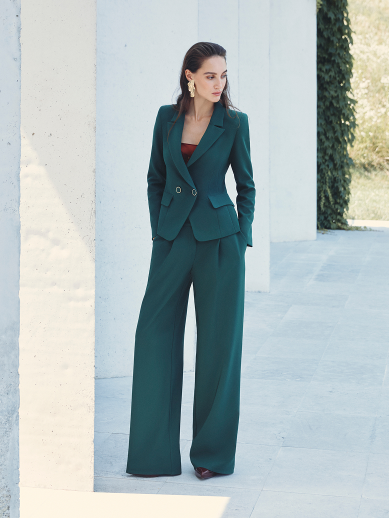 Donna in un completo verde con una maglietta rossa