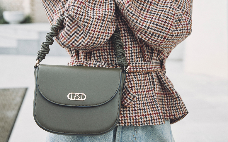 Donna con giacca a quadri e borsa verde
