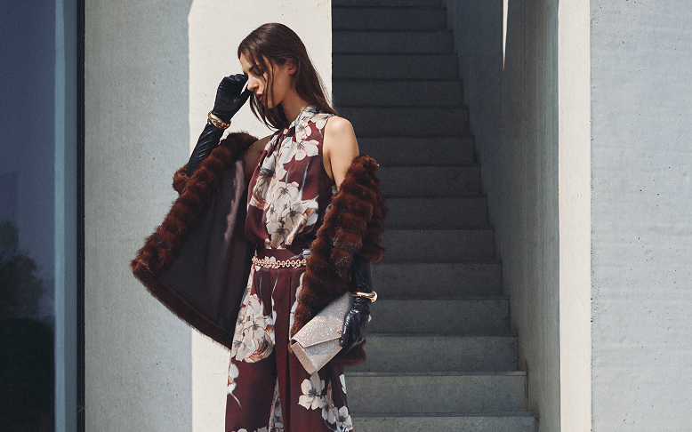 Donna in un vestito floreale con un cappotto di pelliccia