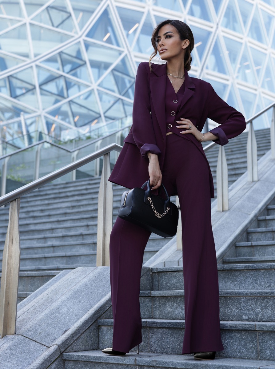 Giorgia Palmas in un completo bordeaux con una borsa nera