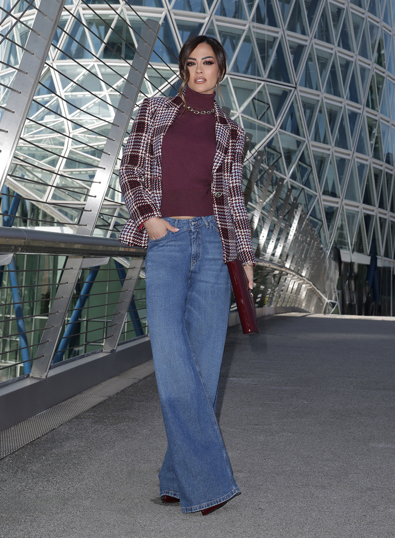 Giorgia Palmas in blazer a quadri e jeans a gamba larga, in piedi con un'espressione sicura