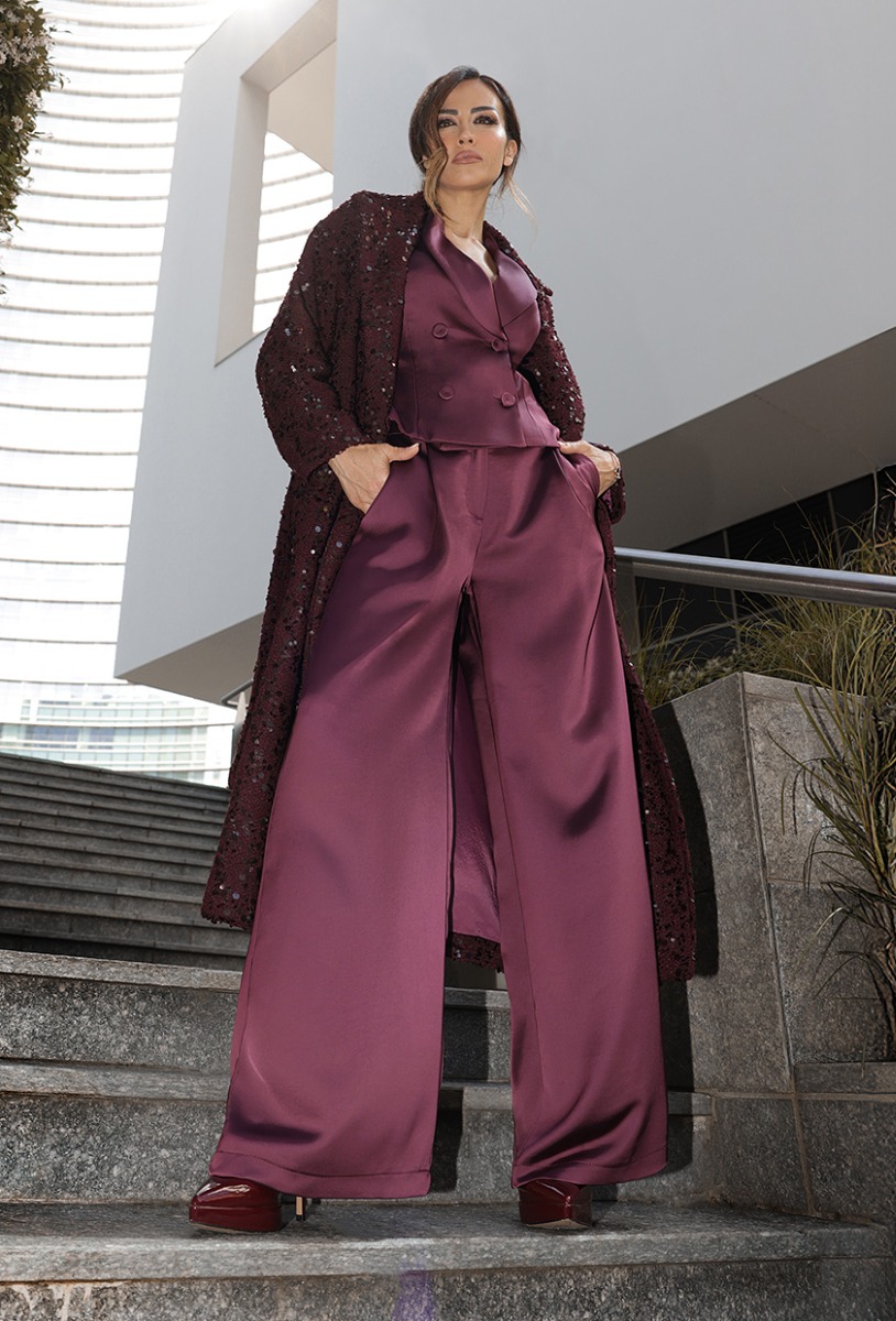 Giorgia Palmas in pantaloni e cappotto bordeaux, in piedi su una scalinata