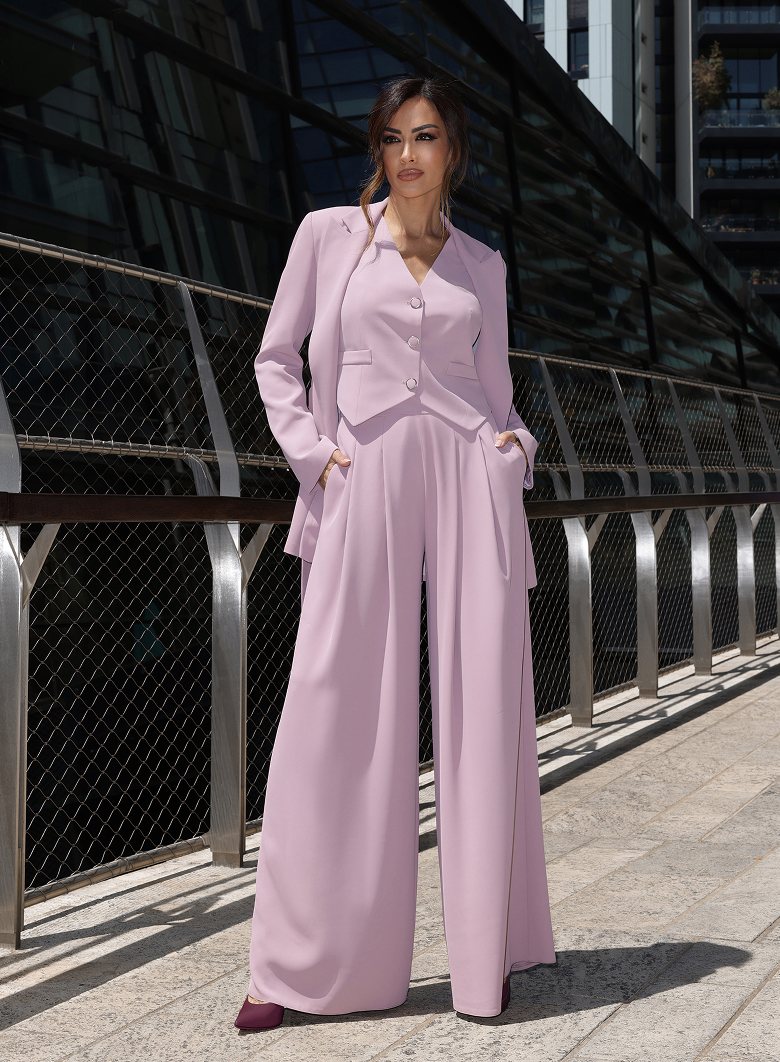Giorgia Palmas in pantaloni e cappotto bordeaux, in piedi su una scalinata
